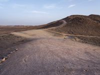 a truck on a dirt road in the desert with rocks and stones on the ground