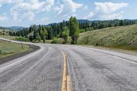 the road is lined with mountains and trees on either side of it, and with two lines in front of each other