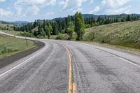 the road is lined with mountains and trees on either side of it, and with two lines in front of each other