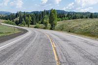 the road is lined with mountains and trees on either side of it, and with two lines in front of each other