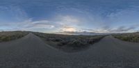 a long winding road with a blue sky in the background and some clouds in the air