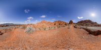 the view of a desert and sky from below, on a sunny day with lots of clouds