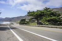 the scenic highway is open to traffic on a clear day with mountains in the background