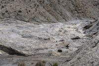 large rocks with rocks scattered on them and dirt ground around them to the top of a mountain