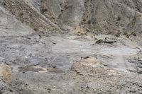 large rocks with rocks scattered on them and dirt ground around them to the top of a mountain