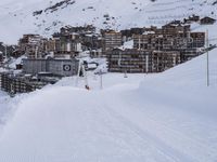 snow covered slope in the middle of a ski area as people ski on it near ski lift