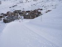 snow covered slope in the middle of a ski area as people ski on it near ski lift