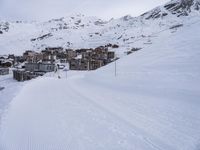 snow covered slope in the middle of a ski area as people ski on it near ski lift