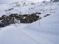 snow covered slope in the middle of a ski area as people ski on it near ski lift