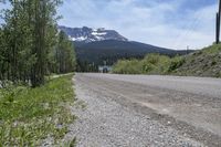 a gravel road and a snowy mountain in the background during the daytime time in british columbia