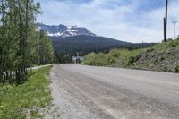 a gravel road and a snowy mountain in the background during the daytime time in british columbia