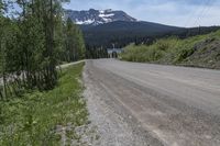 a gravel road and a snowy mountain in the background during the daytime time in british columbia