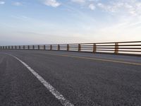 a highway in a scenic area with long railings and the ocean to the far