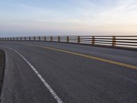 a highway in a scenic area with long railings and the ocean to the far