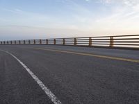 a highway in a scenic area with long railings and the ocean to the far