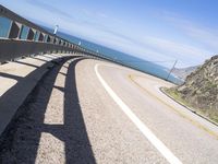 a scenic highway with multiple curves by the water and sky during sunny summer day in california