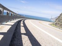 a scenic highway with multiple curves by the water and sky during sunny summer day in california