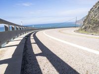 a scenic highway with multiple curves by the water and sky during sunny summer day in california