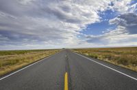 a highway on a cloudy day in the middle of nowhere looking like it is coming out