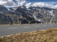 a highway stretches through the middle of a mountainous valley, with some snowy mountains in the distance