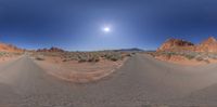 a panoramic photograph shows the empty street, with mountains in the distance and blue sky with clouds