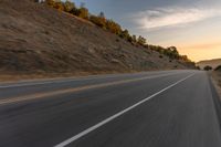 there is an image of a highway at sunset from the window of the vehicle driving down the road