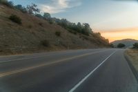 there is an image of a highway at sunset from the window of the vehicle driving down the road