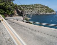 a paved road beside some large boats and a bridge with a bridge to the water