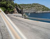 a paved road beside some large boats and a bridge with a bridge to the water