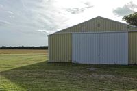 two large grain bins sit in the center of a field, surrounded by silos