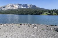 a lake that is surrounded by mountains on the edge of a mountain range in the background