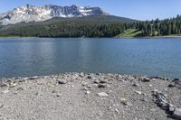 a lake that is surrounded by mountains on the edge of a mountain range in the background