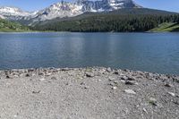 a lake that is surrounded by mountains on the edge of a mountain range in the background