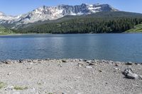 a lake that is surrounded by mountains on the edge of a mountain range in the background