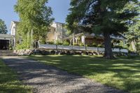 a pathway with rocks that have been placed near a house and trees in the background