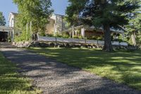 a pathway with rocks that have been placed near a house and trees in the background