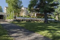 a pathway with rocks that have been placed near a house and trees in the background