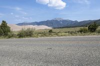 the motorcycle is parked in the side of the road in front of a mountain range