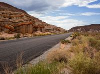 a scenic and scenic landscape of rocks and canyons with a highway below it on a cloudy day