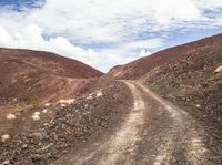 an image of a dirt road running through some rocky hills in the desert in africa