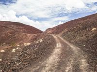 an image of a dirt road running through some rocky hills in the desert in africa