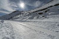 snow is on the road in front of the sun, with no one in sight