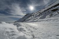 snow is on the road in front of the sun, with no one in sight