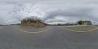 a view looking at the intersection on a paved road with a mountain in the background