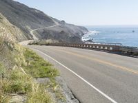 a camera sits at the edge of a scenic mountain highway beside the ocean in california