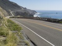 a camera sits at the edge of a scenic mountain highway beside the ocean in california