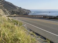 a camera sits at the edge of a scenic mountain highway beside the ocean in california