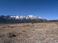 a large open field with mountains in the background on a clear day at high altitude