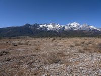 a large open field with mountains in the background on a clear day at high altitude