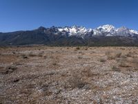 a large open field with mountains in the background on a clear day at high altitude